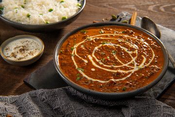 Dal Makhni with rice and raita (curd) and onion rings. 	