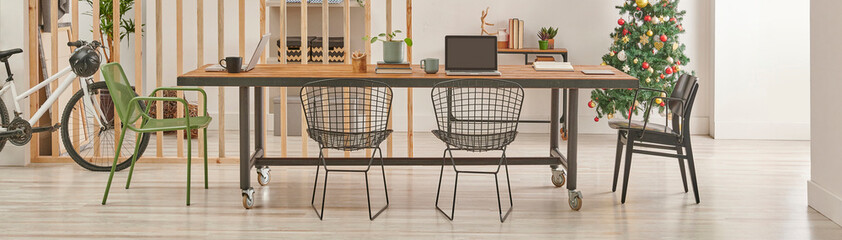 Modern and decorative office interior style with wooden long table, black metal chair, computer and laptop style.
