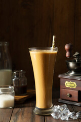  A tall Glass of Cold Coffee, and a coffee grinder and sugar	