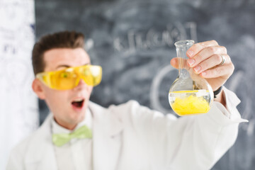 Chemist carries experiment in Chemical laboratory. Test-tubes with chemical reagent. In search of anti viral vaccine. Study funny Chemistry lesson. Scientist Crazy professor in yellow glasses