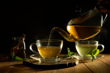 Close up of  green tea being poured from teapot into cup	