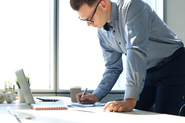 Elegant modern businessman analyzing data while working in office