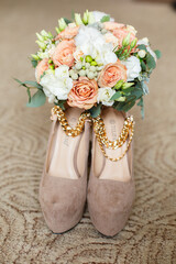 Bride's morning. Wedding accessories in soft colors. Shoes and wedding bouquet on a chair. Elegant chair with wedding accessories in light room