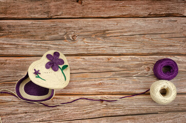 Handmade jewelry box in the shape of a heart on wooden table.