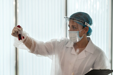 Fototapeta premium Female doctor holding sample for analysis of Covid-19 infectious disea