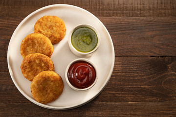 ALOO TIKKIS SERVED HOT WITH CHUTNEY AND SAUCE	