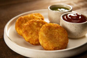 CRISPY ALOO TIKKIS SERVED HOT WITH CHUTNEY AND SAUCE	