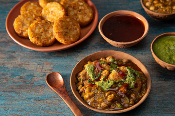 PINDI CHOLE CURRY SERVED WITH ALOO TIKKI AND CHUTNEY	
