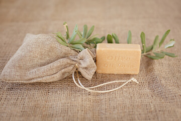 Natural olive Soap and Olive branch on gunny background
