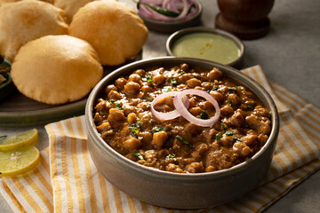 COOKED CHOLE CURRY KEPT ON TABLE ALONG WITH APPETIZERS	