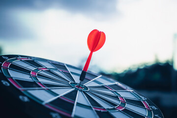 Close up shot of the dart arrow hit on bulleyes of dartboard to represent that the business reached...