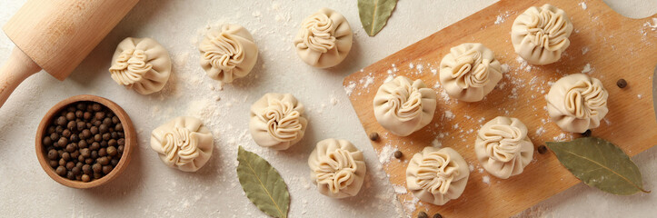 Concept of cooking with raw khinkali and spices on white textured background