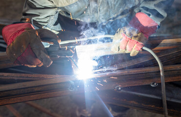 A worker welds metal for a canopy.