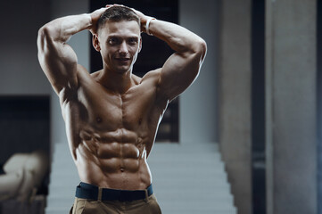Fitness man pumping up abs muscles in gym