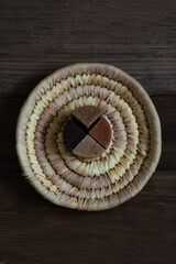 Natural soap on a wicker plate, wooden background. Vertical format. Flat lay