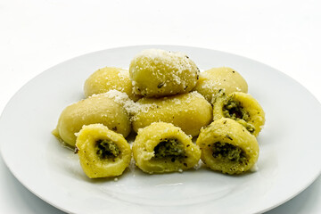 Gnocchi ripieni (dumplings) with Pecorino Romano cheese in a white dish. Traditional italian pasta.