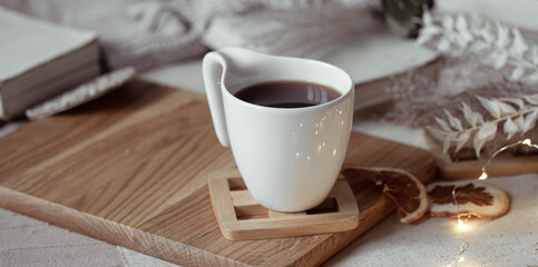 Close up of a white cup with a hot drink on a blurred background.