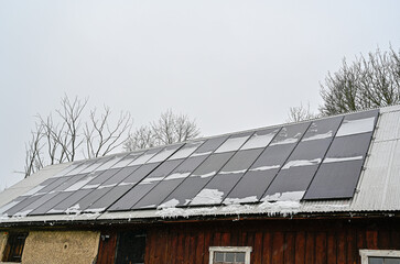 solar panels on roof a grey day with snow on them