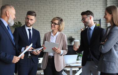 Group of business partners discussing ideas and planning work in office.