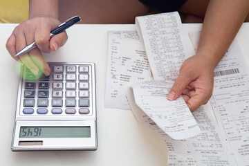 Obraz premium Female hands checking unpaid bills, making calculations and taking notes