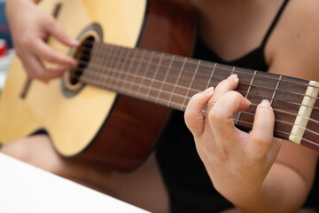 Obraz premium Close up of female hand playing guitar at home