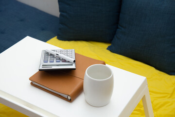 work from home concept. Notebook , pen, calculator on the table on the sofa at home 