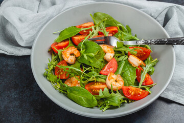 Salad of shrimp prawn and fresh vegetable, leaves of arugula, lettuce.