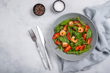 Salad of shrimp prawn and fresh vegetable, leaves of arugula, lettuce.