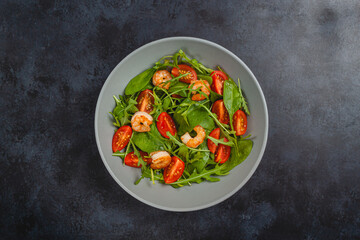 Salad of shrimp prawn and fresh vegetable, leaves of arugula, lettuce.