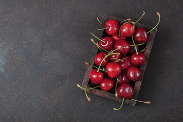 Cherry with leaf on plate and water dropsand on brown stone table