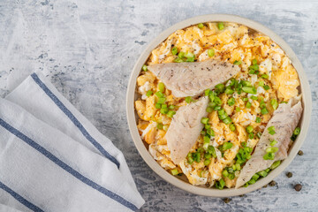Fried eggs with smoked white fish fillet and fresh green onions.