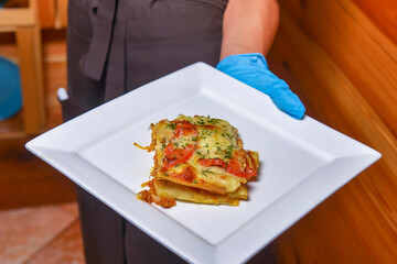 Close-up of a traditional lasagna made with minced beef bolognese sauce. Eating out concept, waiter.