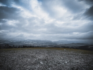Winter landscape covered with light snow with sky and clouds in the background during a dark afternoon.