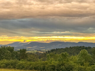 The landscape of the Beskydy Mountains from the viewpoint near Jicin during a colorful sunset and dark clouds in the sky and a view of the surrounding landscape.