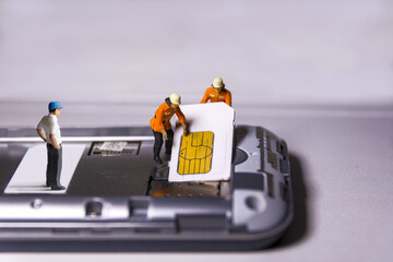 Workers remove and insert sim card into mobile phone