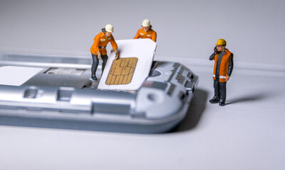 Workers remove and insert sim card into mobile phone