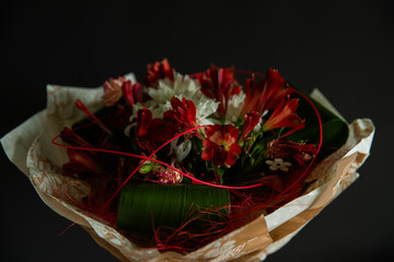 Decorated with a large bouquet in hand of red and white flowers and with accessories wrapped in wrapping paper.