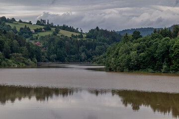 Fototapeta na wymiar Water level of the Bystricka reservoir during a rainy afternoon with dark clouds in the sky.