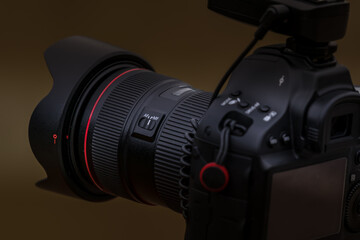 Close-up view of a camera on a tripod photographing a landscape with a medium lens attached.