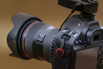 Close-up view of a camera on a tripod photographing a landscape with a medium lens attached.