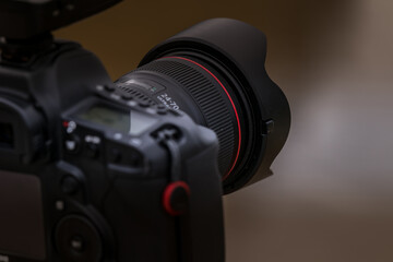 Close-up view of a camera on a tripod photographing a landscape with a medium lens attached.