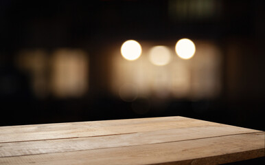empty table on dark background with blurred lamps, cafe restaurant bokeh for your product or customization