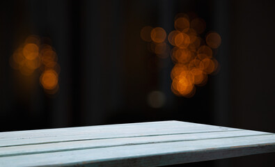 empty table on dark background with blurred lamps, cafe restaurant bokeh for your product or customization