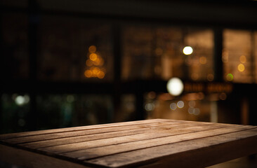 empty table on dark background with blurred lamps, cafe restaurant bokeh for your product or customization