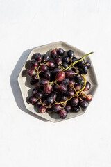 Bunches of fresh ripe red grapes on bright background with copy space.