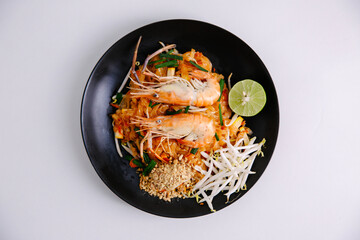 Udon noodle pad thai with shrimp in black plate white background top view asian food Copy space