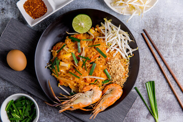 Udon Pad Thai with shrimp in a dark background, top view Asian style food Copy space