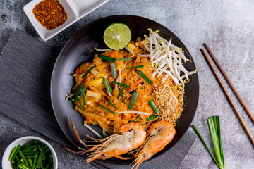 Udon Pad Thai with shrimp in a dark background, top view Asian style food Copy space