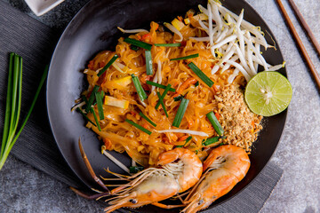 Udon Pad Thai with shrimp in a dark background, top view Asian style food Copy space