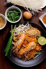 Udon Pad Thai with shrimp in a dark background, top view Asian style food Copy space